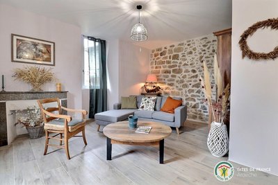 Salon avec mur en pierres apparentes, chaleureux avec canapé et TV